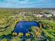 Sprawling aerial view showcasing the community's lush greenery, a serene lake, and well-maintained sports fields nearby at 1230 7Th Ne Ave, Largo, FL 33770