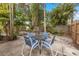 Relaxing backyard patio featuring a table and chairs set amidst lush tropical landscaping with ample seating for outdoor enjoyment at 1230 7Th Ne Ave, Largo, FL 33770