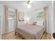 Well-lit bedroom featuring a full bed, bright windows with light filtering curtains, and sleek, modern flooring at 1230 7Th Ne Ave, Largo, FL 33770