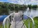 Scenic lake view featuring a charming dock and a tranquil fountain, surrounded by lush greenery for a peaceful retreat at 1230 7Th Ne Ave, Largo, FL 33770