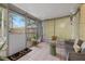 Cozy screened-in porch with comfortable seating, a 'hello' welcome mat, and views of the backyard at 1230 7Th Ne Ave, Largo, FL 33770