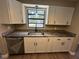 Well-lit kitchen with granite countertops, stainless steel dishwasher and sink under large window at 1501 Howard Pl, Largo, FL 33770