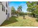 Spacious back yard with green grass and a white fence, offering partial views of a serene lake at 1802 E Park Cir, Tampa, FL 33610