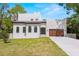 Modern two-story home featuring a well-manicured lawn, arched windows, and a two-car garage at 1802 E Park Cir, Tampa, FL 33610