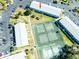 Aerial view of complex featuring tennis courts, lush landscaping, and ample parking near a well-maintained building at 1849 Abrico Dr # 4, Lutz, FL 33558