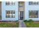 Charming light blue townhouse with a secure, decorative front door and a well-maintained walkway and landscaped garden at 1849 Abrico Dr # 4, Lutz, FL 33558