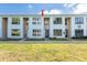 Charming two-story condo featuring light blue exterior, green lawn, and well-maintained landscaping at 1849 Abrico Dr # 4, Lutz, FL 33558