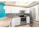Modern kitchen featuring stainless steel appliances, granite countertops, and white cabinetry at 1849 Abrico Dr # 4, Lutz, FL 33558