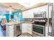 Open-concept kitchen with stainless steel appliances and white cabinets overlooking the dining and living areas at 1849 Abrico Dr # 4, Lutz, FL 33558