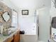 Bright bathroom featuring a shower and tub with white tiled surround and a tiled sink counter at 29523 Waggle Dr, San Antonio, FL 33576