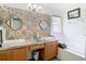 Bathroom featuring double sinks with patterned backsplash and bathtub with white tile surround at 29523 Waggle Dr, San Antonio, FL 33576