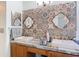 Bathroom featuring double sinks with gold framed mirrors and decorative patterned backsplash at 29523 Waggle Dr, San Antonio, FL 33576