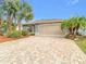 Charming single-story home featuring a brick driveway and tropical landscaping at 29523 Waggle Dr, San Antonio, FL 33576