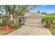 Charming single-story home featuring a brick driveway and tropical landscaping at 29523 Waggle Dr, San Antonio, FL 33576