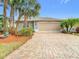 Charming single-story home featuring a brick driveway and tropical landscaping at 29523 Waggle Dr, San Antonio, FL 33576