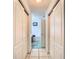 Hallway leading to a bathroom with white cabinets and a glimpse of a soaking tub at 29523 Waggle Dr, San Antonio, FL 33576