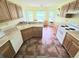 Bright kitchen featuring classic appliances, wood cabinets, and a bay window view of the backyard at 29523 Waggle Dr, San Antonio, FL 33576