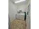 Functional laundry room features white cabinets, tile floor and conveniently placed next to the exterior door at 29523 Waggle Dr, San Antonio, FL 33576
