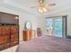 Comfortable main bedroom with tiled floor, ceiling fan, and sliding glass doors to the patio at 29523 Waggle Dr, San Antonio, FL 33576