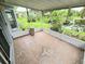 View of covered patio with tiled flooring and pond views with lush landscaping at 29523 Waggle Dr, San Antonio, FL 33576