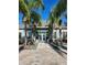 Stunning clubhouse exterior, framed by palm trees, has a welcoming entrance and beautiful landscaping at 3673 Kings Rd # 102, Palm Harbor, FL 34685