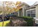 Exterior view of a townhome showcasing lush landscaping, architectural details, and a well-manicured lawn at 3673 Kings Rd # 102, Palm Harbor, FL 34685