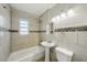 Bathroom features full tub with tile surround, neutral walls, and modern lighting at 4101 W Leila Ave, Tampa, FL 33616