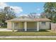 Charming home featuring a covered front porch, fresh lawn, and mature trees at 4101 W Leila Ave, Tampa, FL 33616