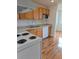 Modern kitchen with wooden cabinets, white appliances, and hard wood flooring at 4915 Bay Ne St # 322, St Petersburg, FL 33703