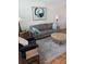 Comfortable living room featuring a plush sofa, accent pillows, a round wood table, and natural light at 4915 Bay Ne St # 322, St Petersburg, FL 33703