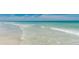 Calm waves gently washing ashore on a pristine, sandy beach at 12261 Eldon Dr, Largo, FL 33774
