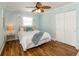 Cozy bedroom featuring a ceiling fan, window, closet, and warm wood flooring at 12261 Eldon Dr, Largo, FL 33774