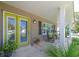 Inviting front porch with rocking chairs and a vibrant green door, complemented by lush greenery at 12261 Eldon Dr, Largo, FL 33774