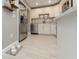 Bright kitchen with stainless steel appliances, white cabinets, light countertops, and wood-look tile floor at 12261 Eldon Dr, Largo, FL 33774