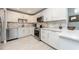 Updated kitchen featuring white cabinets, stainless steel appliances, and stone tile backsplash at 12261 Eldon Dr, Largo, FL 33774