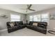 Bright living room featuring comfortable leather couches, neutral tones, and ample natural light from large windows at 12261 Eldon Dr, Largo, FL 33774