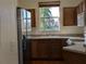 Sunlit kitchen with stainless steel refrigerator, tile floors, and a garden view window at 12287 Country White Cir, Tampa, FL 33635