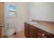 A bright bathroom features a toilet, vanity with a stone countertop and a window at 2103 W Vina Del Mar Blvd, St Pete Beach, FL 33706