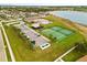 Aerial view of community tennis courts, parking and a lake in a residential neighborhood at 2604 Dakota Rock Dr, Ruskin, FL 33570