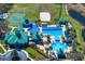 Aerial shot of community pool, playground, tennis courts, and open green space surrounded by manicured landscaping at 8205 Prairie Ridge Way, Tampa, FL 33647