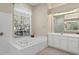Bright bathroom featuring a soaking tub, vanity, and ample natural light at 8205 Prairie Ridge Way, Tampa, FL 33647