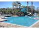 Sparkling community pool with a water slide, sun deck, and lush greenery at 8205 Prairie Ridge Way, Tampa, FL 33647