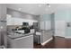Well-lit kitchen featuring stainless steel appliances, an eat-in island, and a combination of white and gray color palette at 8205 Prairie Ridge Way, Tampa, FL 33647