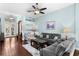 Bright living room with hardwood floors, neutral paint, ceiling fan and doorway to the foyer at 8205 Prairie Ridge Way, Tampa, FL 33647