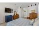 Spacious main bedroom featuring a large TV, neutral colors, and walk-in access to the main bathroom at 8205 Prairie Ridge Way, Tampa, FL 33647