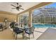 Inviting outdoor dining area featuring a ceiling fan, grill, and screened-in pool for relaxed entertaining at 8205 Prairie Ridge Way, Tampa, FL 33647