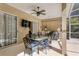 Relaxing outdoor patio with ceiling fan, mounted television, and dining set perfect for entertaining at 8205 Prairie Ridge Way, Tampa, FL 33647