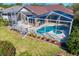 Aerial view of the screened pool area featuring a patio, lush landscaping, and outdoor living space at 8205 Prairie Ridge Way, Tampa, FL 33647