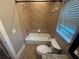Ceramic tiled bathroom features a tub-shower combo with a window to let in natural light at 8503 Kentucky Derby Dr, Odessa, FL 33556