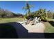 Outdoor fire pit area with chairs, surrounded by lush landscaping and a brick-paved patio at 8503 Kentucky Derby Dr, Odessa, FL 33556